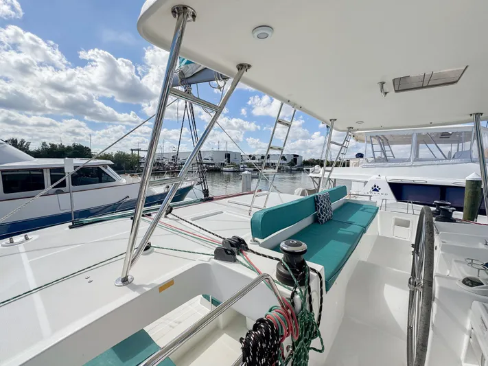 Sunshine Yacht Photos Pics 2017 Lagoon 450 F catamaran with spacious deck, teal seating, and marina view.