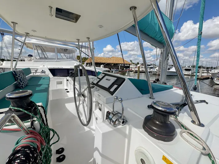Sunshine Yacht Photos Pics 2017 Lagoon 450 F catamaran cockpit with steering wheel, ropes, and marina view.