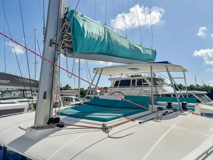 Sunshine Yacht Photos Pics 2017 Lagoon 450 F catamaran with turquoise sail cover, docked under a clear sky.