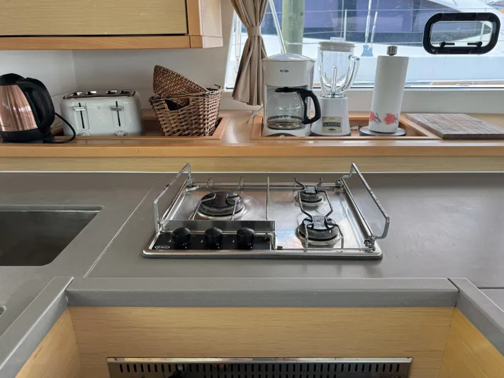 Sunshine Yacht Photos Pics Modern kitchen in 2017 Lagoon 450 F yacht with stove, appliances, and window view.