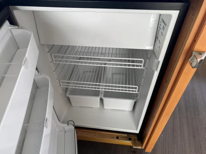 Sunshine Yacht Photos Pics Open refrigerator inside Lagoon 450 F yacht, 2017 model, with empty shelves and storage bins.