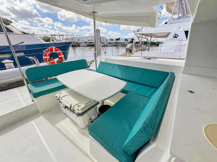 Sunshine Yacht Photos Pics Outdoor seating area on 2017 Lagoon 450 F catamaran with turquoise cushions and table.