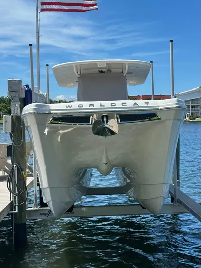  Yacht Photos Pics 2024 World Cat 280ccx catamaran docked, viewed from the front, with American flag above.