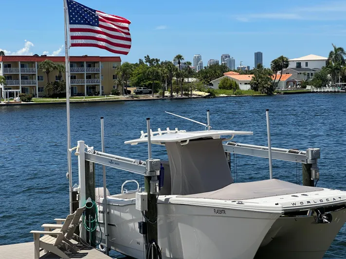  Yacht Photos Pics 2024 World Cat 280ccx boat docked by waterfront with American flag and city skyline.