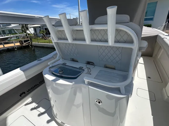  Yacht Photos Pics 2024 World Cat 280ccx boat interior with rod holders and storage, docked by waterfront homes.