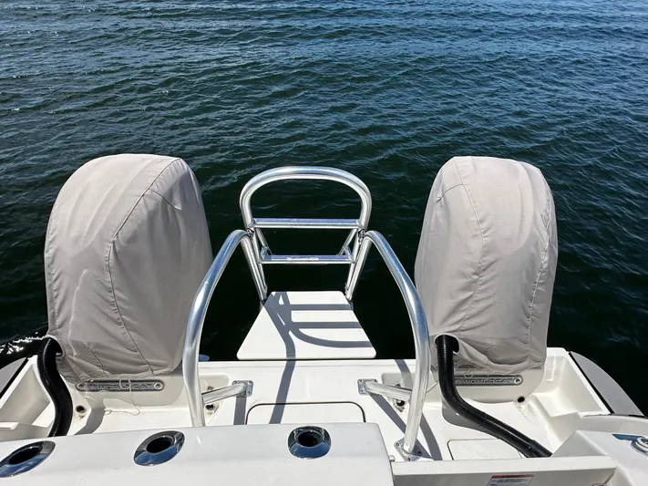  Yacht Photos Pics 2024 World Cat 280ccx boat with covered engines, rear view over water.