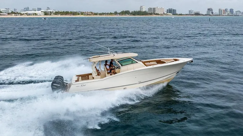  Yacht Photos Pics 2018 Scout 420 LXF boat cruising on open water near a city skyline.