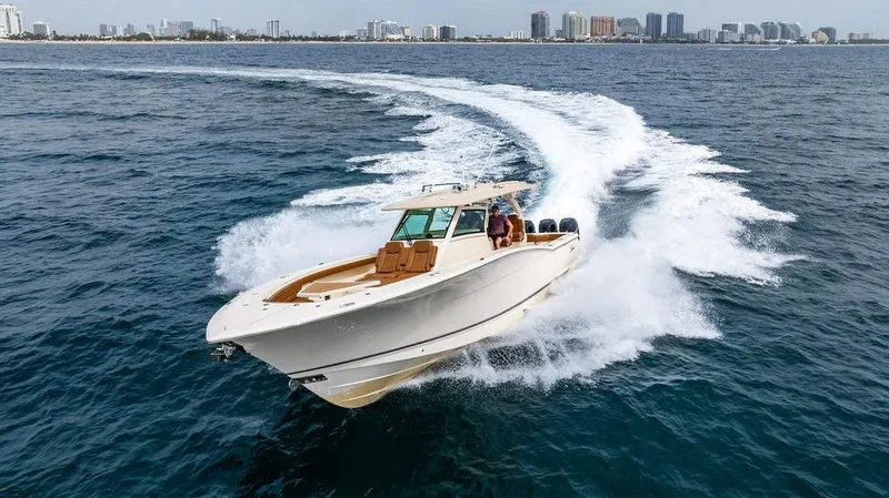  Yacht Photos Pics 2018 Scout 420 LXF boat cruising on open water near a city skyline.