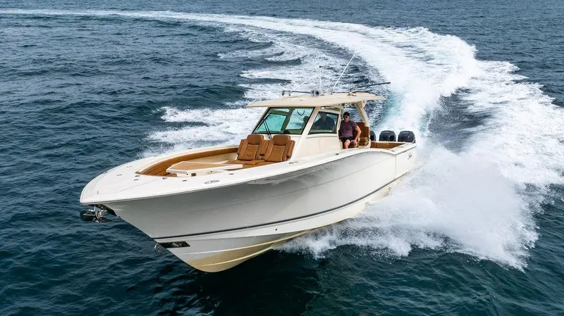  Yacht Photos Pics 2018 Scout 420 LXF boat cruising on open water, creating a dynamic wake.
