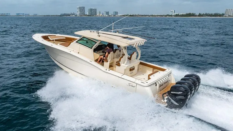  Yacht Photos Pics 2018 Scout 420 LXF boat cruising on open water with multiple Mercury engines.