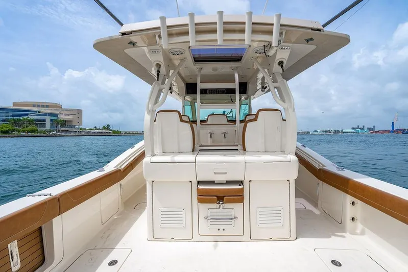  Yacht Photos Pics 2018 Scout 420 LXF boat interior with seating, on a calm waterfront.