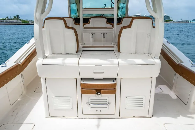  Yacht Photos Pics 2018 Scout 420 LXF boat interior with seating and storage, docked by the water.