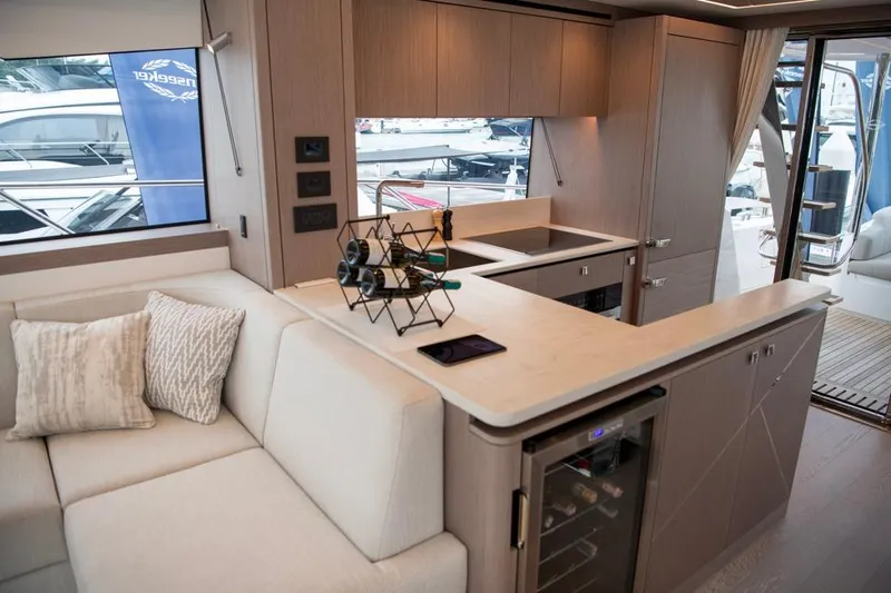  Yacht Photos Pics Luxurious interior of 2025 Sunseeker Manhattan 68 yacht with modern kitchen and seating area.
