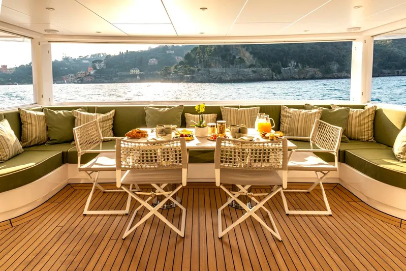  Yacht Photos Pics Luxurious Heesen 38m yacht deck with elegant dining setup, overlooking serene waters, built in 2001.