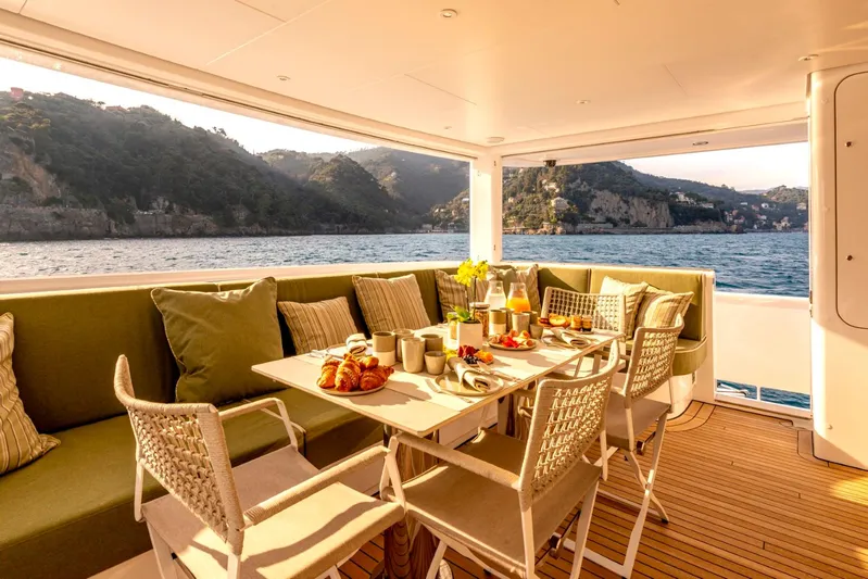  Yacht Photos Pics Luxurious Heesen 38m yacht deck with breakfast setup, scenic ocean view, and comfortable seating.