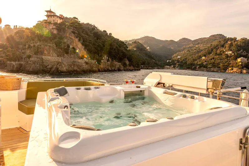  Yacht Photos Pics Luxurious Heesen 38m yacht with jacuzzi, scenic coastal view, and sunset ambiance.