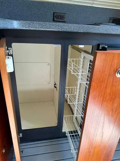 Martin Yacht Photos Pics Open cabinet with wire shelves in 2002 Luhrs 36 Convertible boat interior.