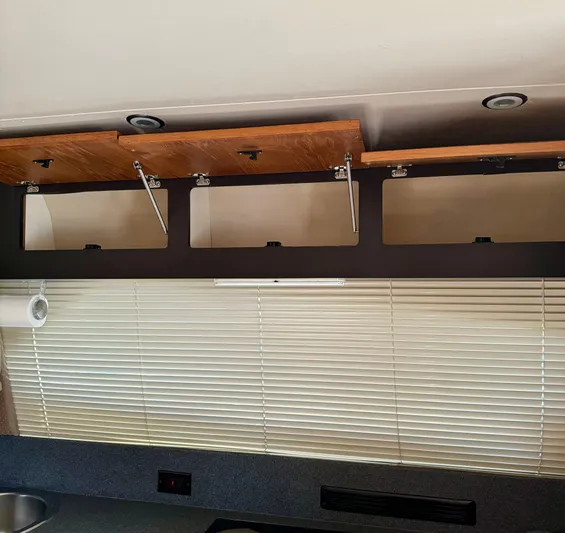 Martin Yacht Photos Pics Open wooden cabinets above blinds in a 2002 Luhrs 36 Convertible boat interior.