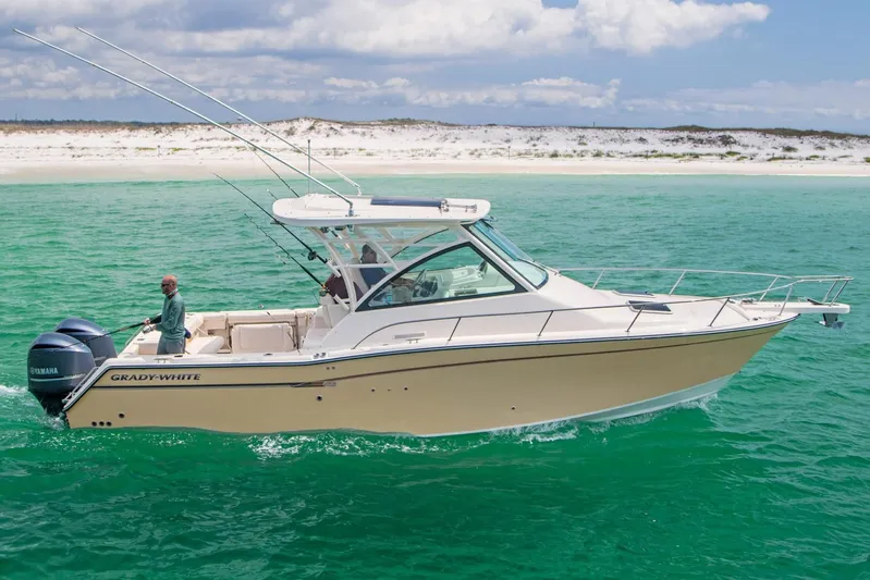  Yacht Photos Pics 2018 Grady-White Express 330 boat cruising in clear turquoise waters near a sandy beach.