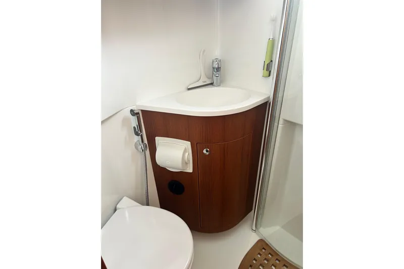  Yacht Photos Pics Compact bathroom in 2022 Botnia Targa 37 yacht with wooden cabinetry and modern fixtures.