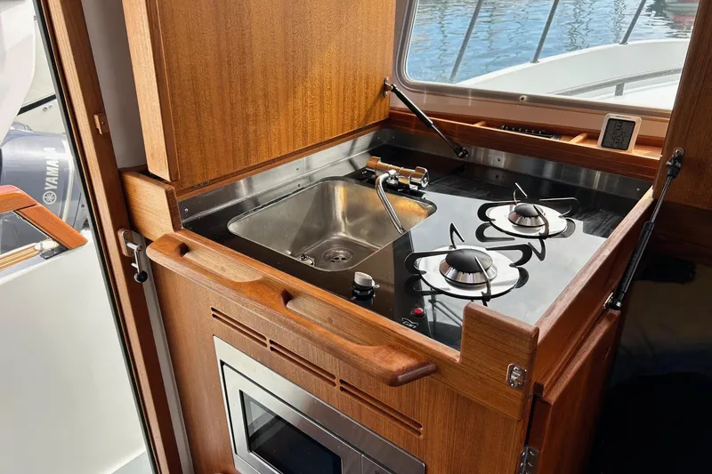  Yacht Photos Pics Compact kitchen area in 2022 Botnia Targa 37 boat with stove and sink.