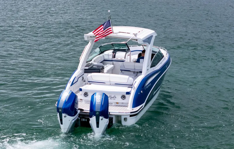  Yacht Photos Pics 2024 Formula 310 BR boat with dual engines on open water, American flag displayed.