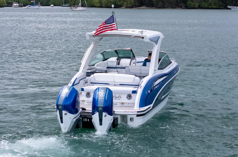  Yacht Photos Pics 2024 Formula 310 BR boat cruising on a lake with American flag.