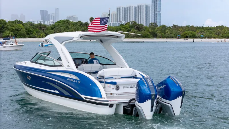  Yacht Photos Pics 2024 Formula 310 BR boat with dual Mercury engines on a scenic waterway.