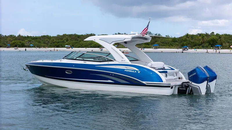  Yacht Photos Pics 2024 Formula 310 BR boat on water, blue and white design, near a beach.