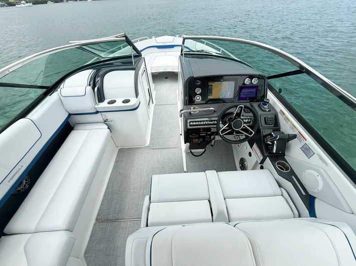  Yacht Photos Pics 2024 Formula 310 BR boat interior with modern dashboard and seating on water.