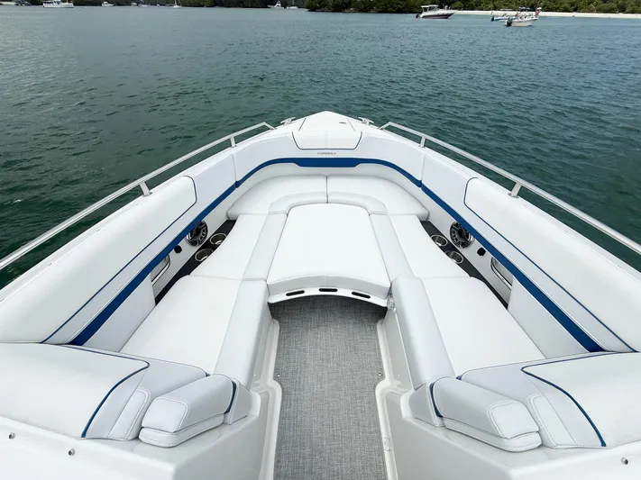  Yacht Photos Pics 2024 Formula 310 BR boat interior with white seating and blue accents on the water.