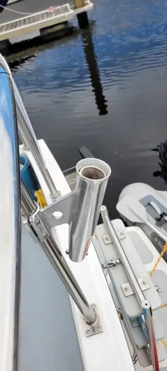 Funky Monkey Yacht Photos Pics Stainless steel rod holder on a 2001 Monk 36 boat, docked by calm water.