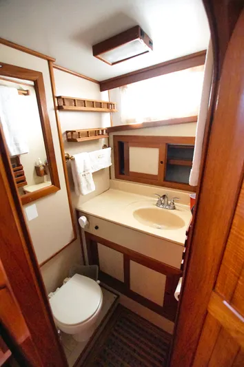 Funky Monkey Yacht Photos Pics Bathroom interior of 2001 Monk 36 (Hull #215) yacht, featuring sink, toilet, and wooden cabinetry.