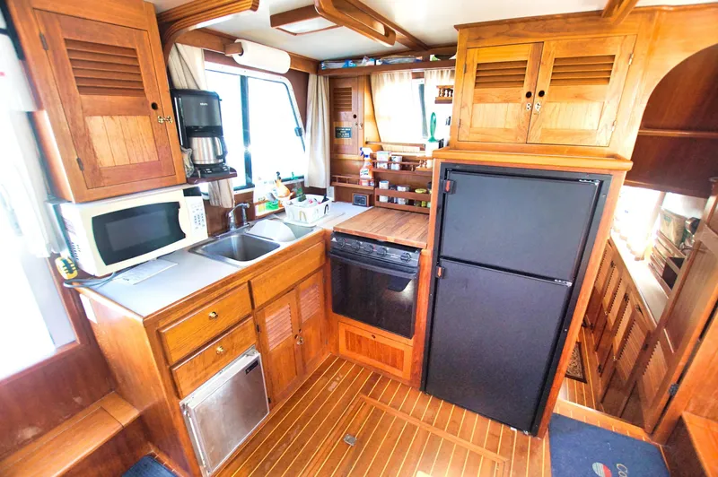 Funky Monkey Yacht Photos Pics Wooden kitchen interior of 2001 Monk 36 boat, featuring appliances and ample storage.