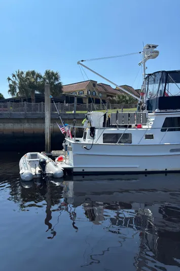 Funky Monkey Yacht Photos Pics 2001 Monk 36 (Hull #215) yacht docked with inflatable boat, clear sky, and waterfront view.