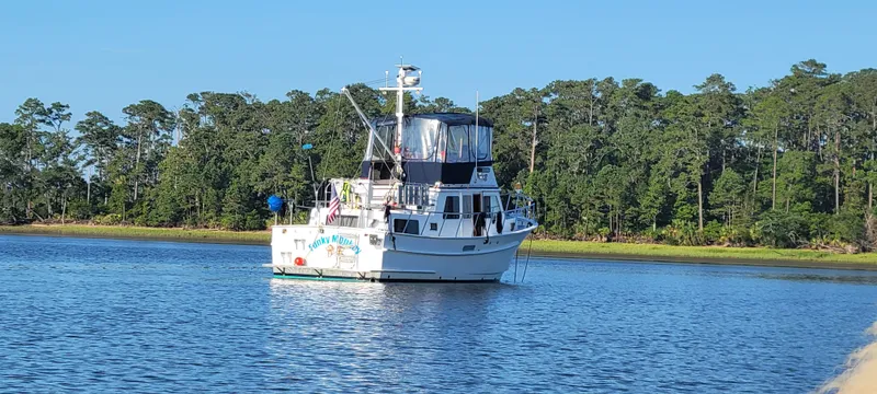 Funky Monkey Yacht Photos Pics A 2001 Monk 36 yacht anchored on a serene lake with a forested backdrop.