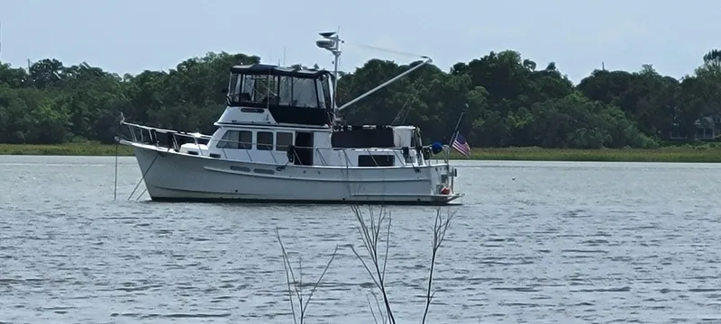 Funky Monkey Yacht Photos Pics A 2001 Monk 36 boat anchored on a calm river with trees in the background.