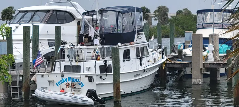 Funky Monkey Yacht Photos Pics Monk 36 (Hull #215) 2001 boat docked with inflatable dinghy, American flag displayed.