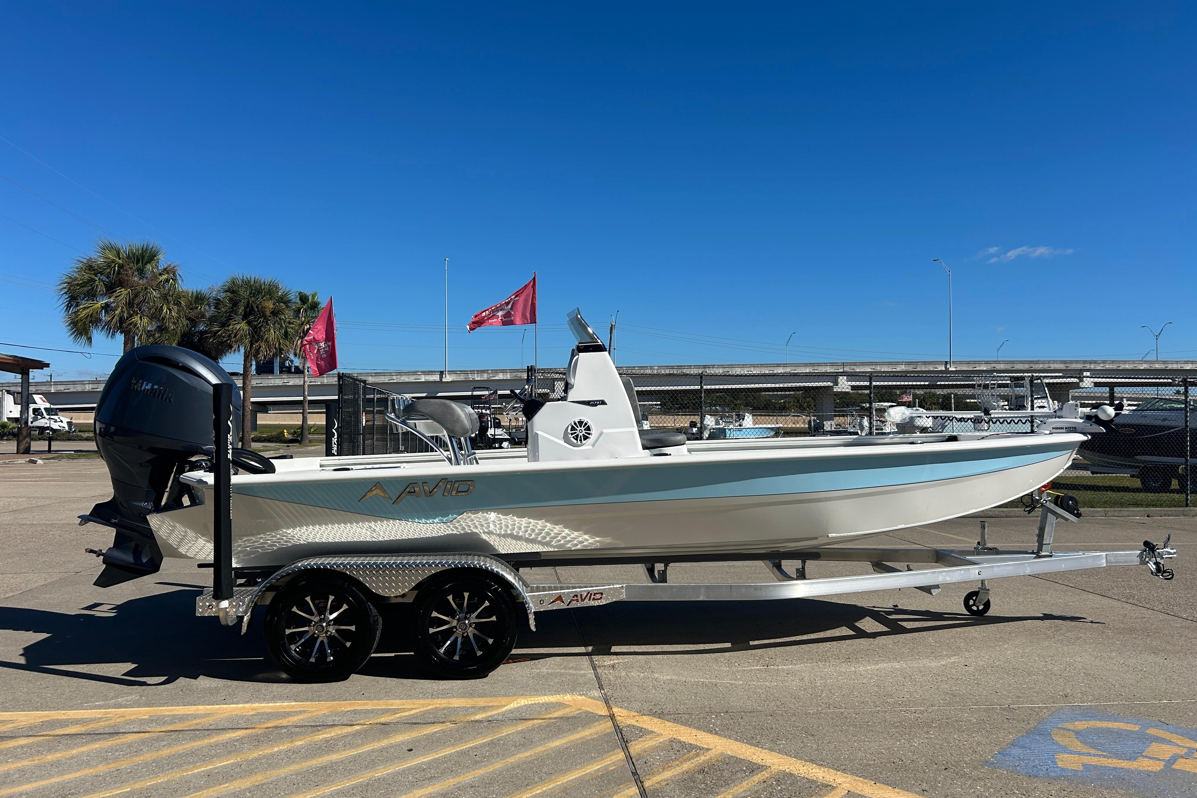 2025 Avid 21 FST boat on trailer, parked outdoors under clear blue sky.
