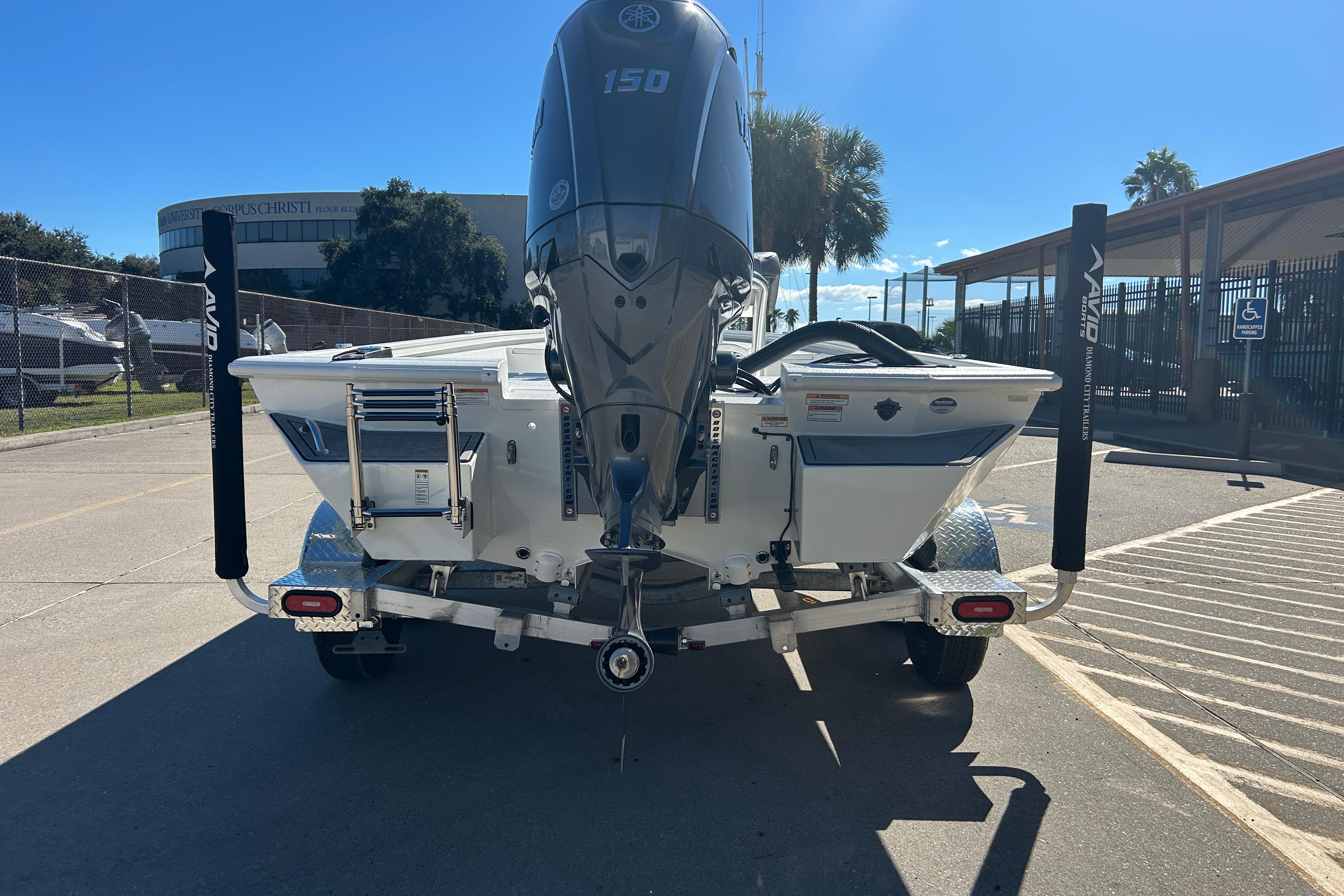Avid 21 FST 2025 boat on trailer, rear view with Yamaha 150 engine.