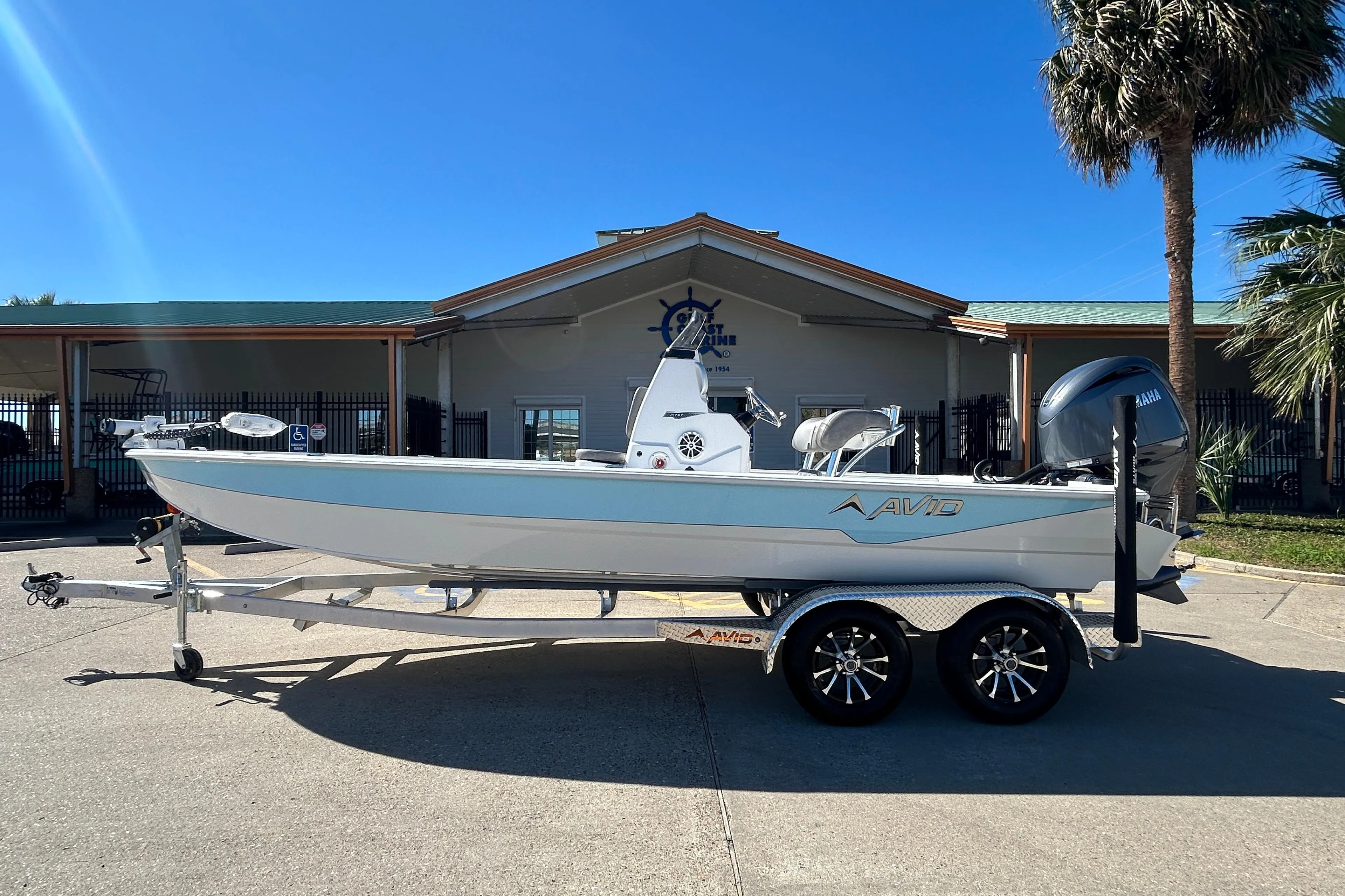 2025 Avid 21 FST boat on trailer, parked outdoors under clear blue sky.