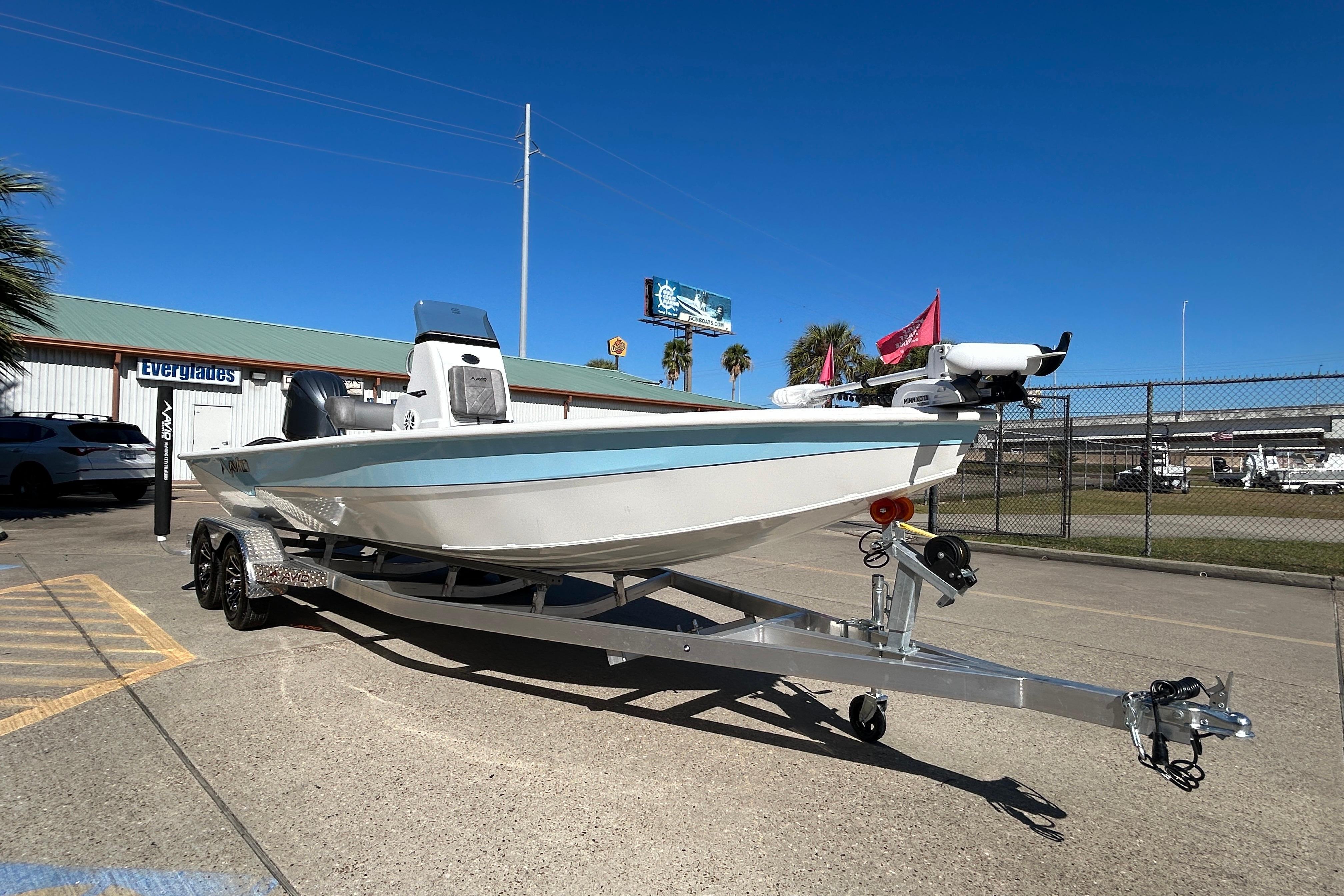 2025 Avid 21 FST boat on trailer, parked outdoors under clear blue sky.