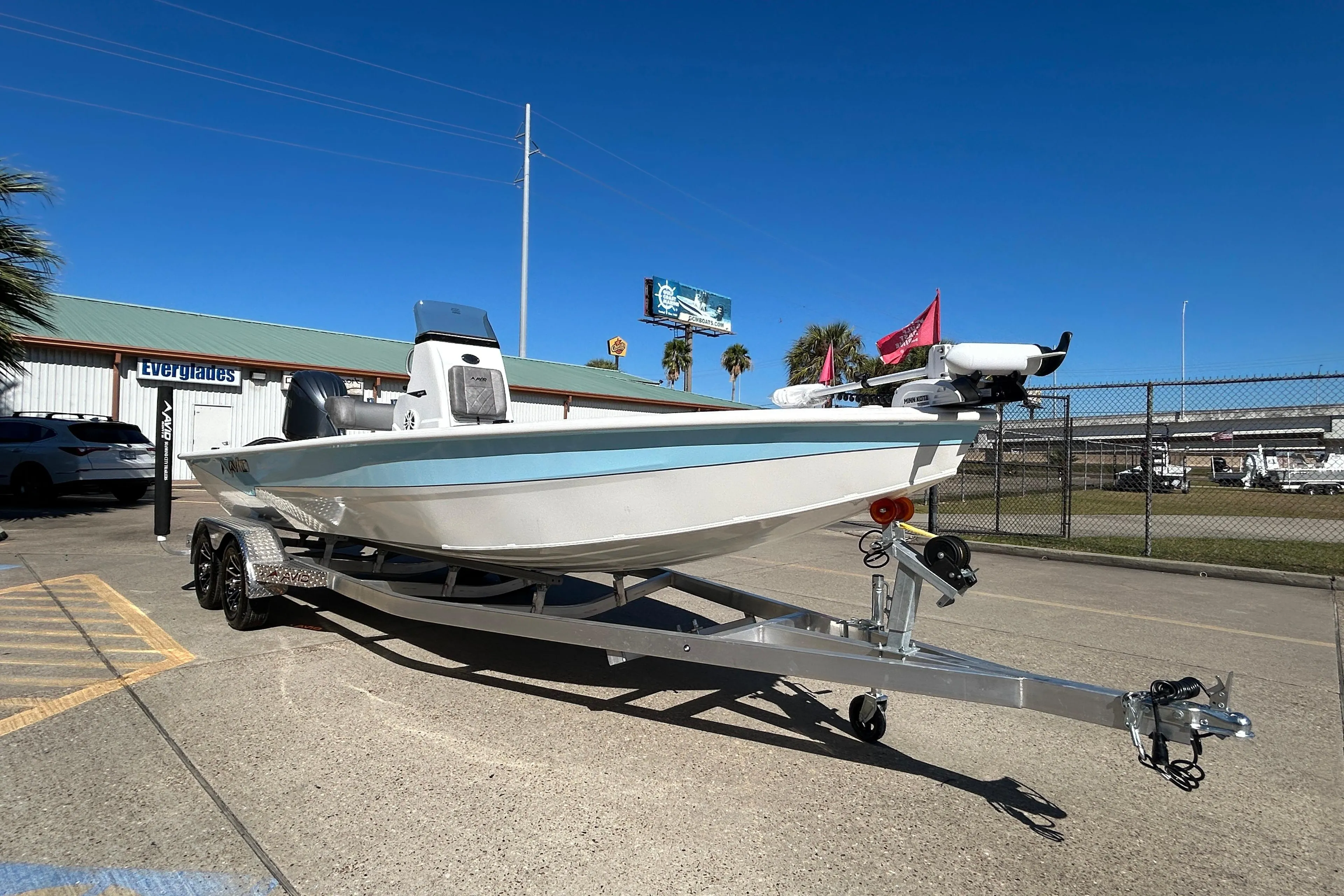 2025 Avid 21 FST boat on trailer, parked outdoors under clear blue sky.