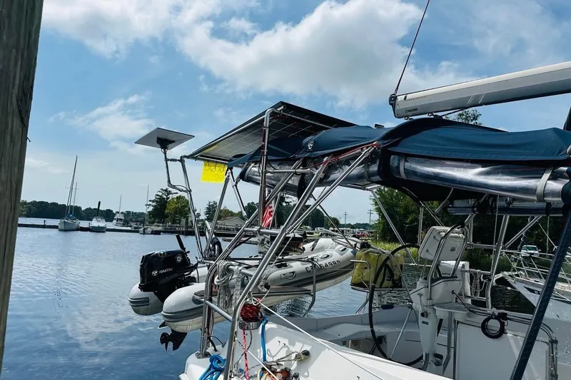 Free Range Yacht Photos Pics 2005 Hunter 44 sailboat docked, featuring solar panels and a dinghy, under a clear sky.