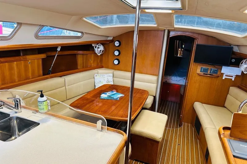 Free Range Yacht Photos Pics Interior of a 2005 Hunter 44 sailboat with wood finish and cozy seating area.