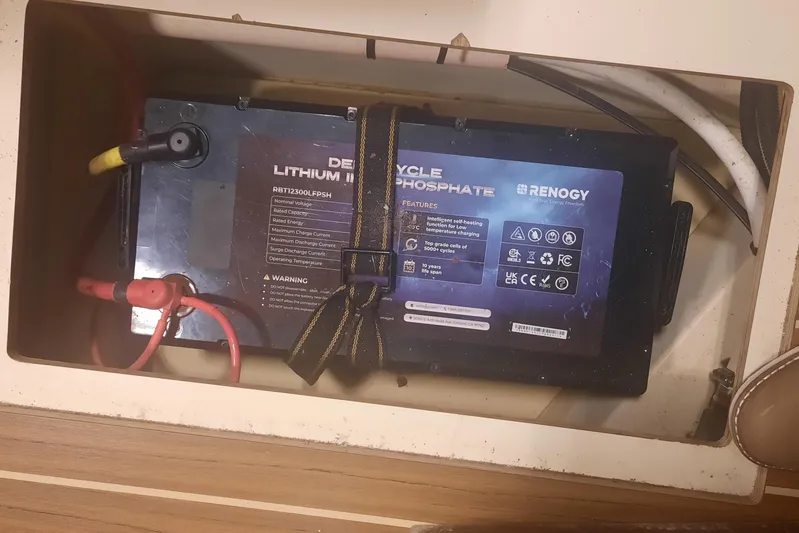 Free Range Yacht Photos Pics Lithium battery in 2005 Hunter 44 boat, secured with straps, featuring Renogy branding.