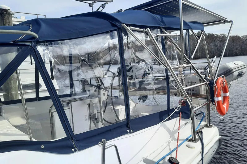 Free Range Yacht Photos Pics 2005 Hunter 44 sailboat with blue canopy and solar panel, docked by the water.
