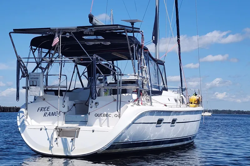 Free Range Yacht Photos Pics Sailboat "Free Range," Hunter 44, 2005 model, anchored in calm waters under blue sky.