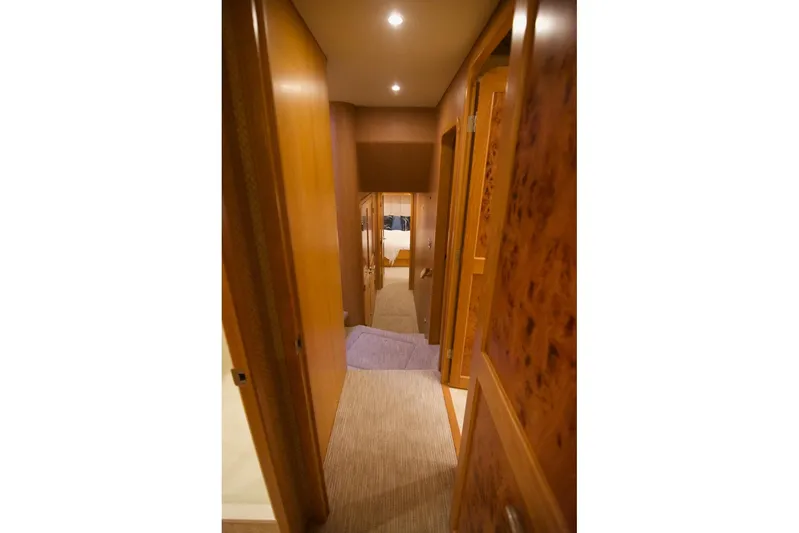 T.t. Amore Yacht Photos Pics Interior hallway of 2004 West Bay Cockpit Pilot House Motoryacht, featuring wood paneling and soft lighting.