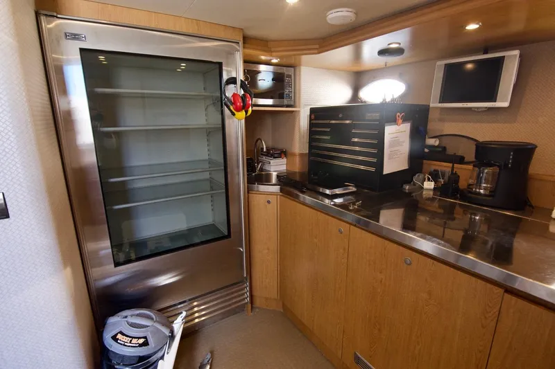 T.t. Amore Yacht Photos Pics 2004 West Bay Cockpit Pilot House Motoryacht kitchen with stainless steel fridge and wooden cabinetry.